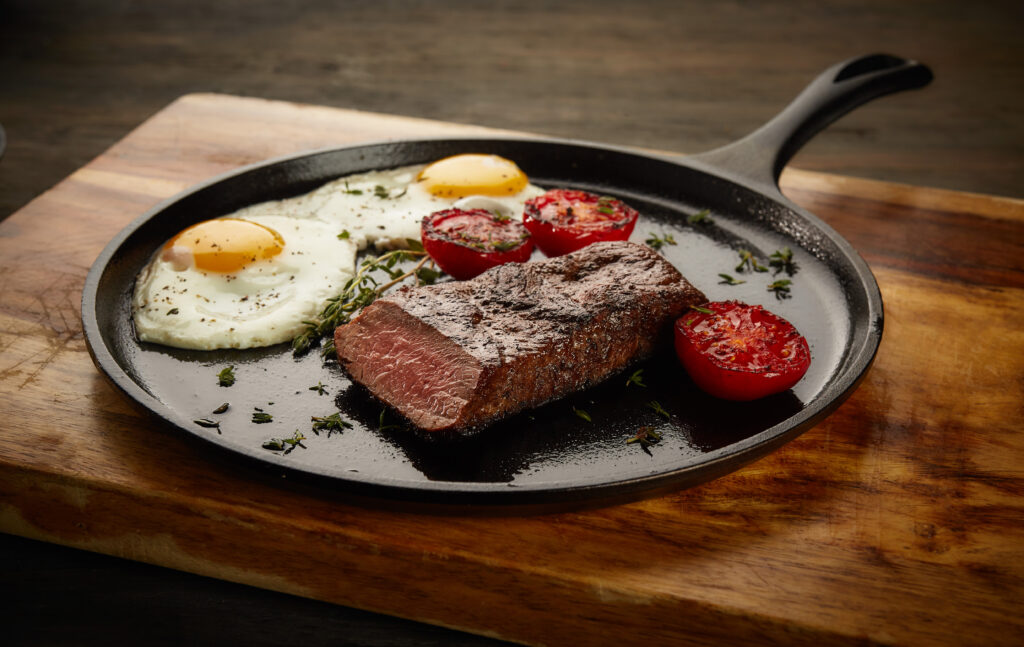 country style steak and eggs with grilled tomatoes and tzatziki sauce